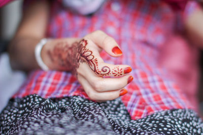 Midsection of woman with henna tattoo