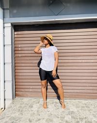 Full length of woman standing against wall in south african township