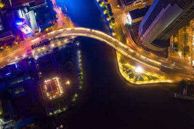 High angle view of light trails on road amidst buildings at night