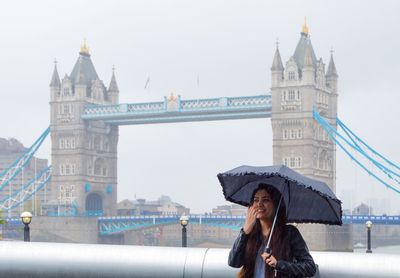 Low angle view of woman standing by bridge