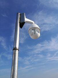 Low angle view of security camera against sky