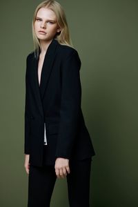 Portrait of businesswoman standing against black background