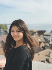 Portrait of smiling young woman standing on beach