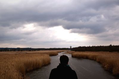 Scenic view of field against cloudy sky