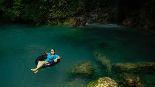 Portrait of smiling mature woman on inflatable ring in river