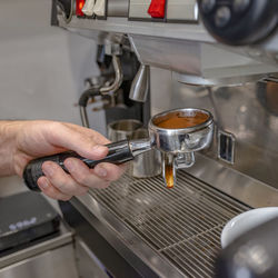 Midsection of man having coffee at cafe