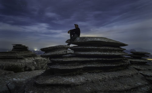 Low angle view of statue on rock against sky