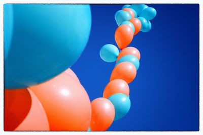 Close-up of balloons against blue sky