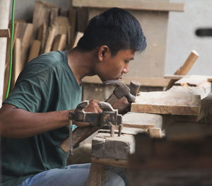 Side view of man working at workshop