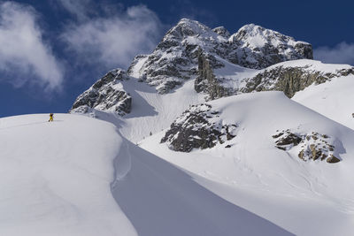 Low angle view of hiker on snow covered mountain
