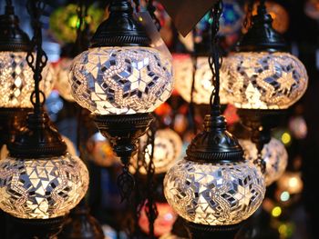 Close-up of illuminated lanterns hanging at market stall