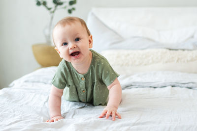 Portrait of cute baby girl sleeping on bed at home