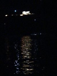 Illuminated buildings by river at night