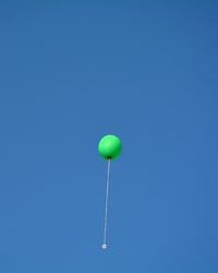 Low angle view of balloons against blue sky