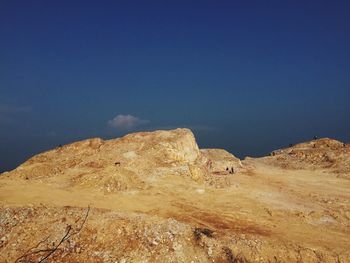 Rock formations on landscape against clear blue sky