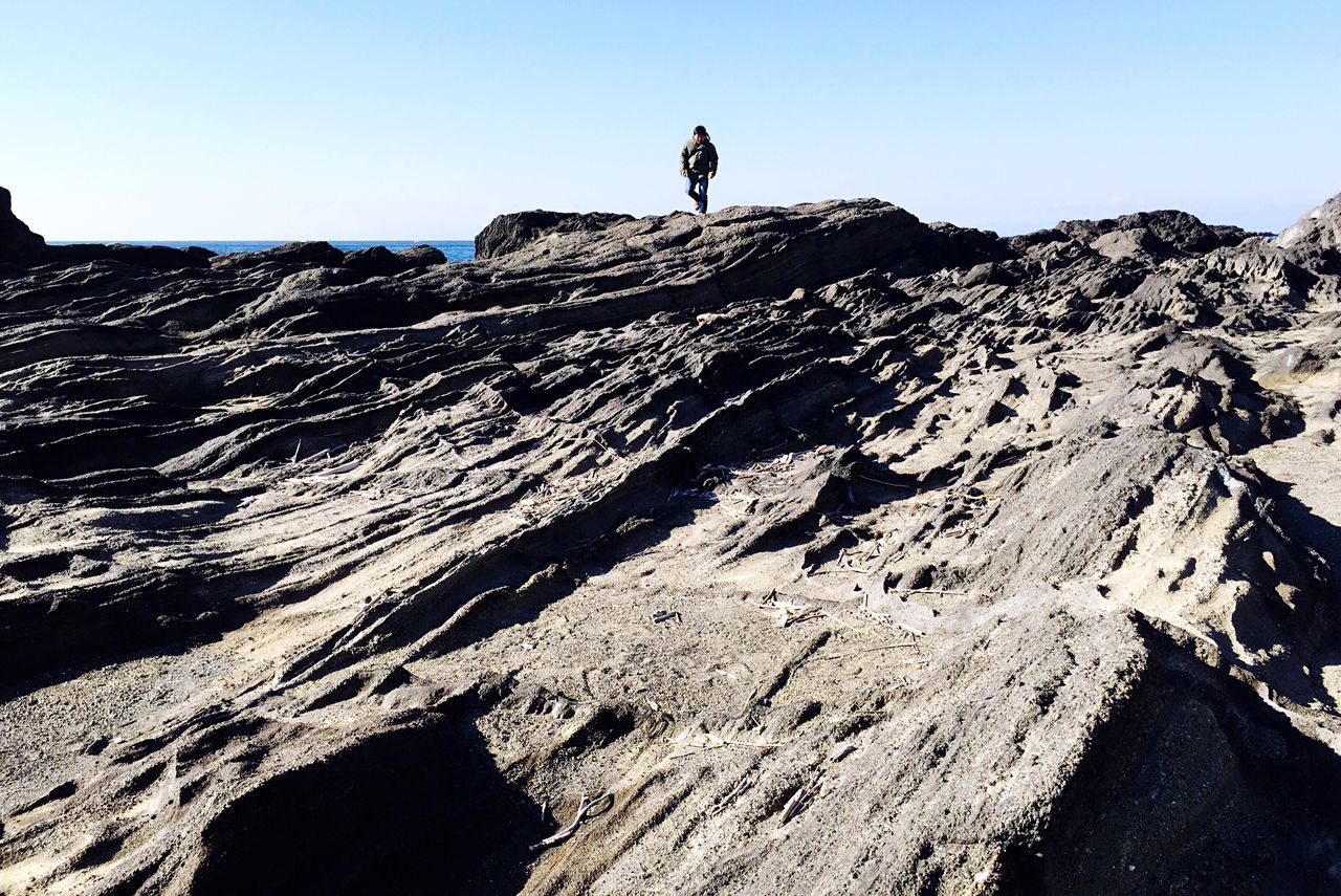 leisure activity, full length, lifestyles, clear sky, outdoors, landscape, one person, real people, day, adventure, hiking, low angle view, nature, courage, scenics, men, beauty in nature, mountain, women, arid climate, cold temperature, people, adult