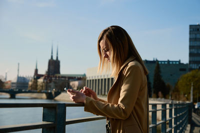 Caucasian woman using smartphine at city street