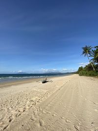 Scenic view of beach against blue sky