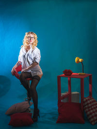 Portrait of fashion model sitting on chair in studio