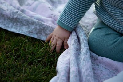 Rear view of woman hand on grass
