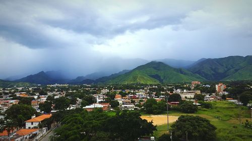 Townscape by mountains against sky