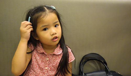 Portrait of cute girl against wall