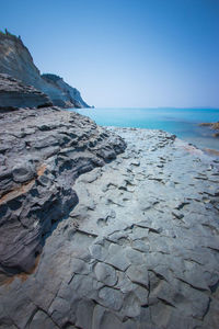 Scenic view of beach against clear blue sky