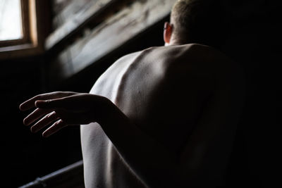 Rear view of shirtless man in darkroom