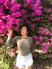 Woman looking at pink blooming flowers
