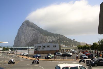 Cars on road against cloudy sky