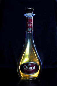 Close-up of illuminated bottle against black background