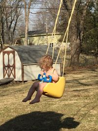 Boy sitting on swing at playground