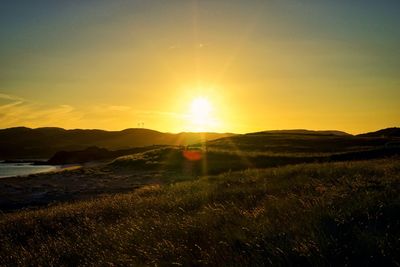 Scenic view of field against sky during sunset