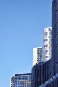 Low angle view of modern buildings against clear blue sky