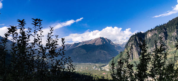 Panoramic view of landscape and mountains against blue sky