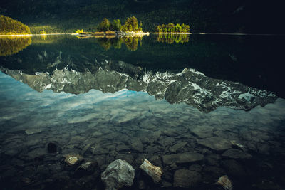 Beautiful alpine summer sunset at the lakeshore with reflections - eibsee lake in bavaria, germany