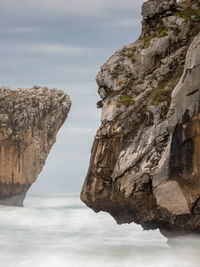 Rock formation on sea against sky