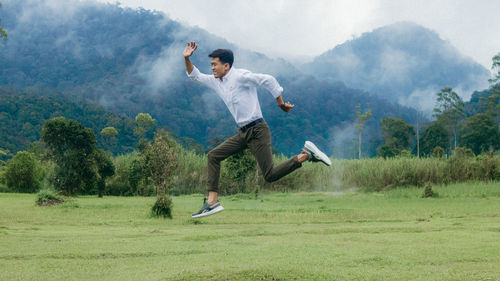 Full length of young man jumping on mountain