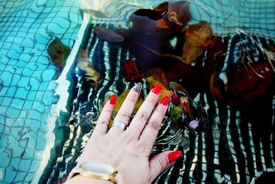 High angle view of woman with nail art over swimming pool