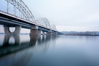 Railway bridge over river with reflection