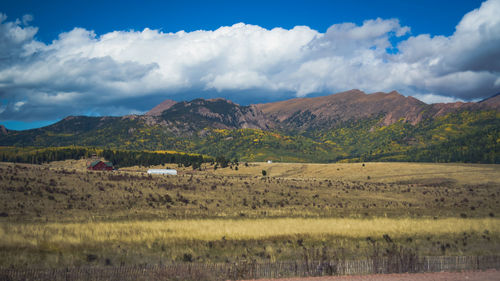 Scenic view of field and mountains against sky