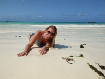 Portrait of woman on beach against sky