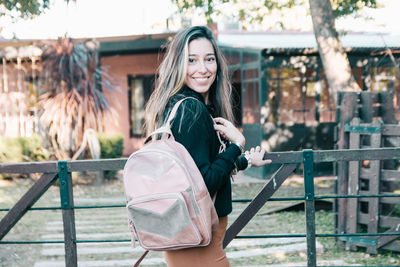 Smiling beautiful woman wearing backpack