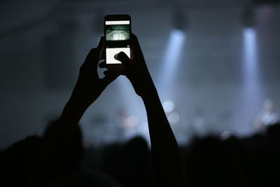 Close-up of hand using smart phone at night