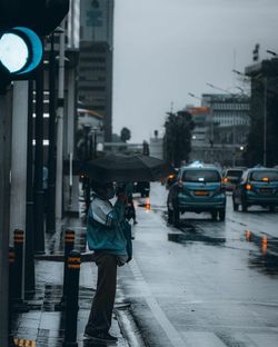 Man walking on wet street in rainy season