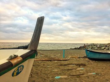 Boat moored on beach against sky