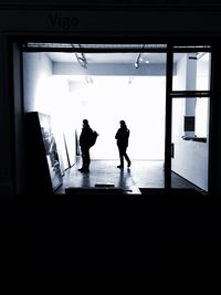 Rear view of silhouette people walking in corridor