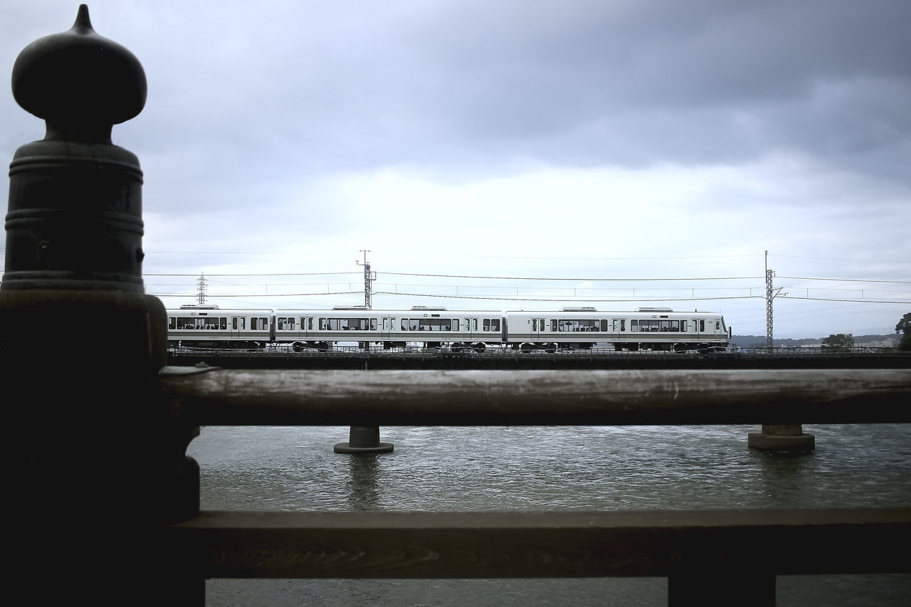 BRIDGE OVER RIVER BY CITY AGAINST SKY