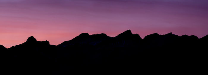 Silhouette mountains against clear sky at sunset