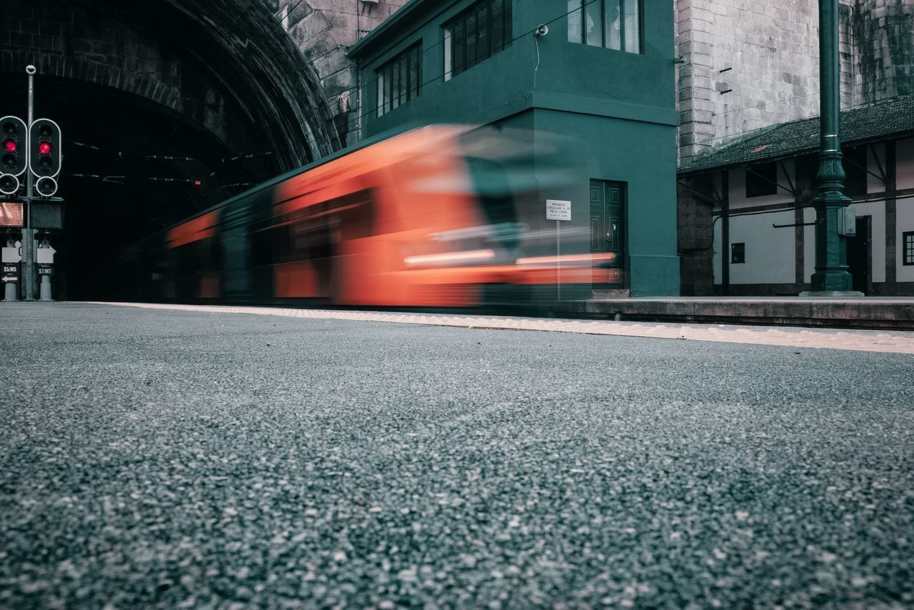 BLURRED MOTION OF TRAIN ON CITY STREET